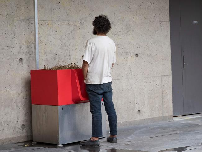 A man uses a "uritrottoir" public urinal on August 13, 2018, near the Gare de Lyon in Paris. - The city of Paris has begun testing "uritrottoirs", dry public urinals intended to be ecological and odorless, but that make some residents cringe. (Photo by Thomas SAMSON / AFP)