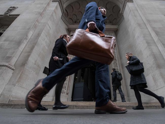 TOPSHOT - Commuters walk past an entrance to the Lloyds building in central London on March 29, 2017.  British Prime Minister Theresa May will formally launch Brexit today after signing the letter to begin the country's departure from the European Union. / AFP PHOTO / CHRIS J RATCLIFFE