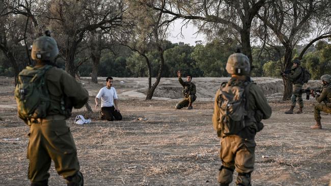 Israeli soldiers detain a man while on patrol on October 12, 2023 near Kibbutz Beeri, the place where 270 revellers were killed by Hamas militants during the Supernova music festival on October 7. Picture: AFP