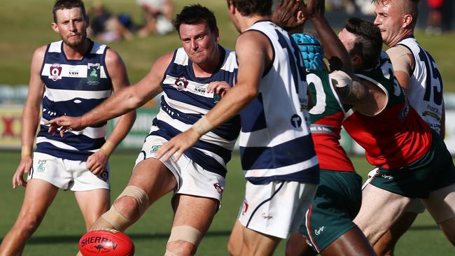 Port Douglas' Daniel Moore has a kick blocked by South Cairns defenders in the AFL Cairns men's grand final match between the Port Douglas Crocs and the South Cairns Cutters, played at Cazalys Stadium. PICTURE: BRENDAN RADKE