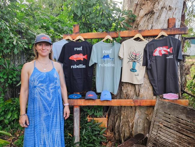 Katt Andryskova with products from her clothing brand Reef Rebellion which raises funds for non-for-profits to help sustain the Great Barrier Reef and the marine life that calls it home