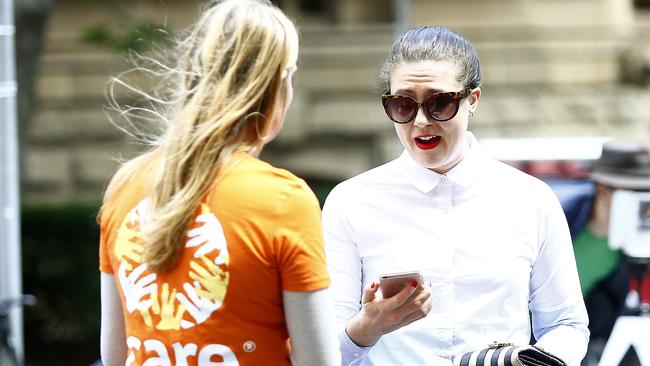 Central Sydney reporter Heather McNab tries to rebuff the approach of a charity chugger. Picture: John Appleyard