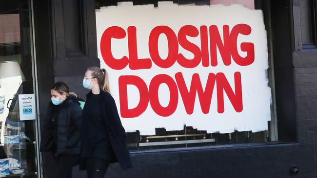 People walk past a business closing down in Melbourne. Picture: NCA NewsWire/ David Crosling