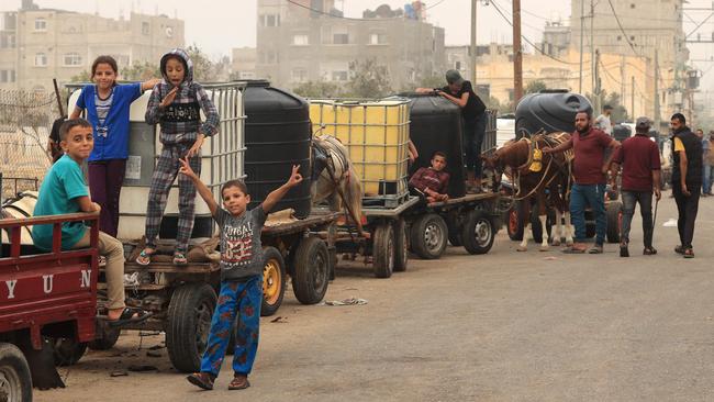 Palestinian civilians wait to collect water using horse and donkey drawn carts, in Rafah in the southern Gaza Strip on Saturday. Picture: AFP