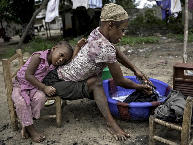 Jestina Koko, 25, pictured with her five-year-old daughter Satta, has been unable to walk since the age of three. They sleep in the hallway of a home with no electricity or toilet, and have no possessions. Picture: Renee Byer