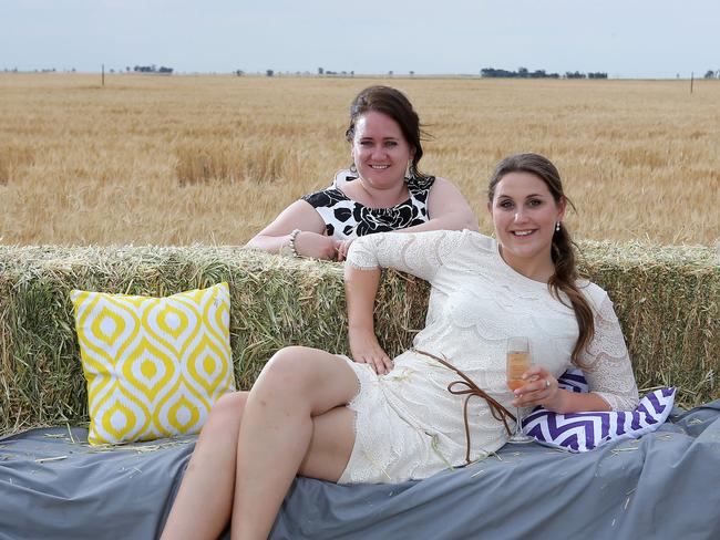 Emma Healy, from Rupanyup and Janne Koch, from Hamburg, Germany lounge on the hay furniture at the Rupanyup Barley Banquet. Picture: Yuri Kouzmin