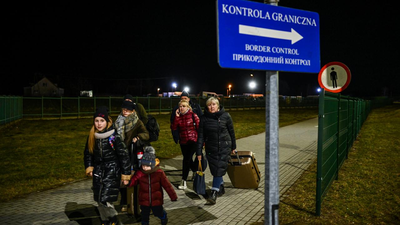 Ukrainian citizens carry suitcases after crossing the Polish-Ukrainian border on February 24, into Medyka. Picture: Omar Marques/Getty Images