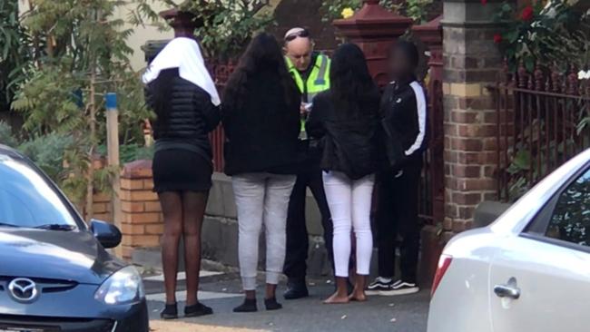 Police speak to youths outside the holiday rental property. Picture:Paul Dowsley/7News