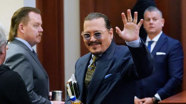 Johnny Depp gestures to the gallery as he leaves for a break in the courtroom at the Fairfax County Circuit Courthouse in Fairfax, Virginia, on May 23, 2022. (Photo by Steve Helber / POOL / AFP)