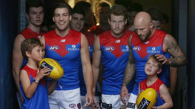 Oliver (left) and Wilba Green, sons of former Melbourne captain Brad Green, led the Demons onto the MCG in honour of their mother Anna. Pic: Michael Klein