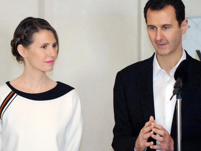 A handout picture released by the official Syrian Arab News Agency (SANA) shows Syrian President Bashar al-Assad (R) speaking next to his wife Asma as they receive members of the army and their mother's to celebrate Mother's Day in the capital Damascus on March 21, 2016. / AFP PHOTO / SANA AND AFP PHOTO / STRINGER / == RESTRICTED TO EDITORIAL USE - MANDATORY CREDIT 