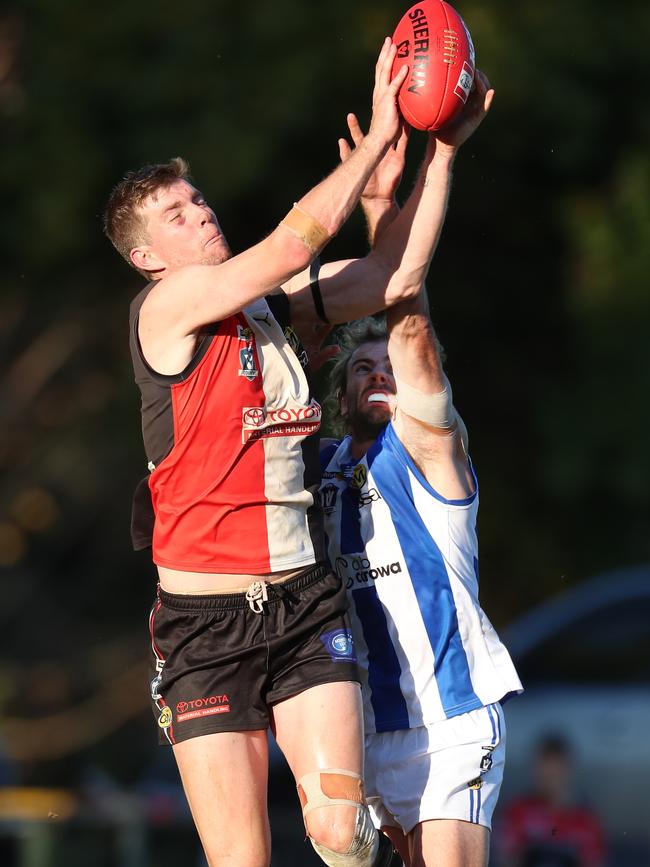 Myrtleford’s Ryley Sharp soars over Corowa-Rutherglen’s Jason Wells.