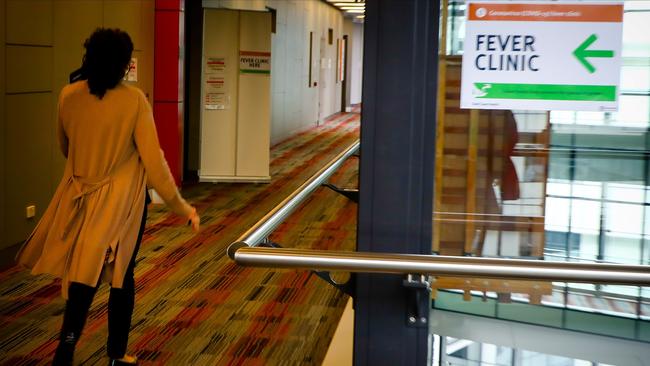 A sign directing visitors to the Fever Clinic is pictured at the entrance to the Gold Coast University Hospital on March 13, 2020. (Photo by Patrick HAMILTON / AFP)