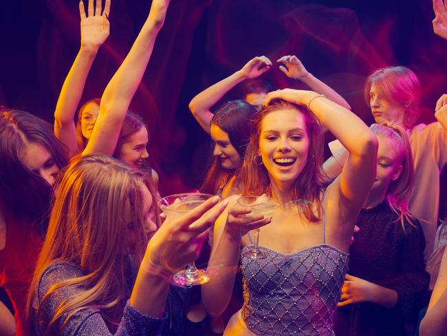 Group of young people, boys and girls, attending party, dancing, having fun over dark background in neon light. Winter holidays. Concept of youth culture, leisure time activity, fun, lifestyle   istock image