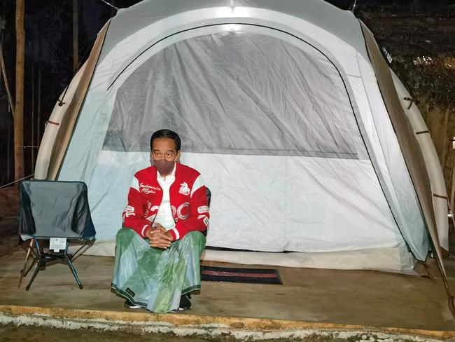 This handout photo taken and released on March 14, 2022 from the Presidential Palace shows Indonesiaâs President Joko Widodo standing next to a tent as he and his entourage camp at a ground in Penajam Paser Utara, where the government plans to move its capital from Jakarta to East Kalimantan. (Photo by AGUS SUPARTO / PRESIDENTIAL PALACE / AFP) / -----EDITORS NOTE --- RESTRICTED TO EDITORIAL USE - MANDATORY CREDIT "AFP PHOTO / Presidential Palace" - NO MARKETING - NO ADVERTISING CAMPAIGNS - DISTRIBUTED AS A SERVICE TO CLIENTS