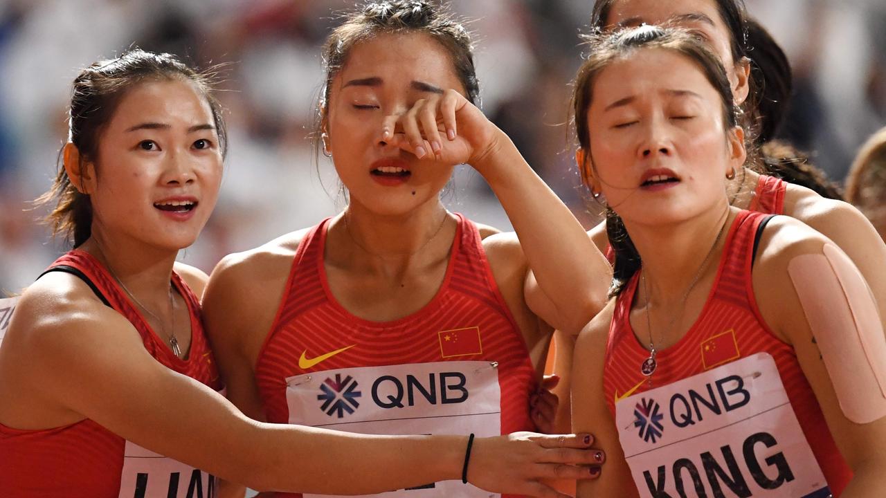 China's Liang Xiaojing (L) and Kong Lingwei (R) comfort teammate Ge Manqi after the Women's 4x100m Relay final at the 2019 IAAF Athletics World Championships.