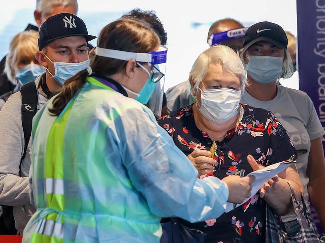 Compliance Officers check travellers documents as they arrive at Melbourne Airport from Brisbane. Picture: NCA NewsWire / Ian Currie