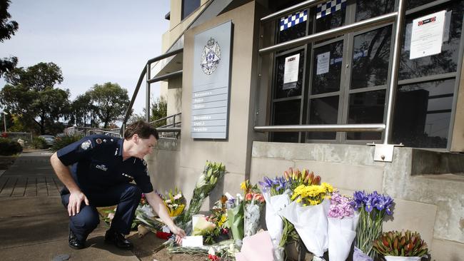 Floral tributes for the officers outside Boroondara Police Station. Deputy. Commissioner Shane Patton places a letter among the tributes. Picture: David Caird