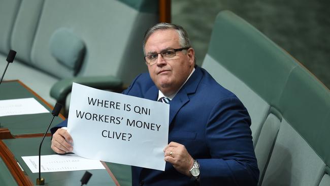 Backbencher Ewen Jones holds up a prop as PUP Leader Clive Palmer makes an announcement in the House of Representatives at Parliament House in Canberra, Wednesday, May 4, 2016. Palmer announced will not seek re-election for parliament's lower house. (AAP Image/Lukas Coch) NO ARCHIVING