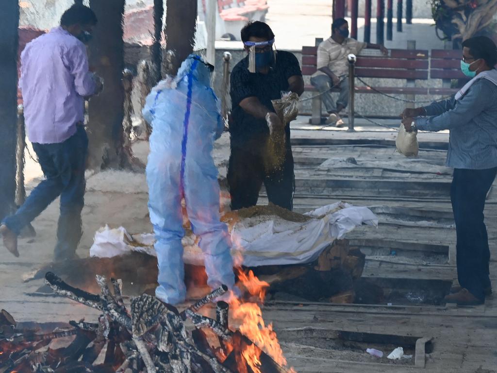 Relatives perform the last rites during the cremation of their loved one. Picture: AFP