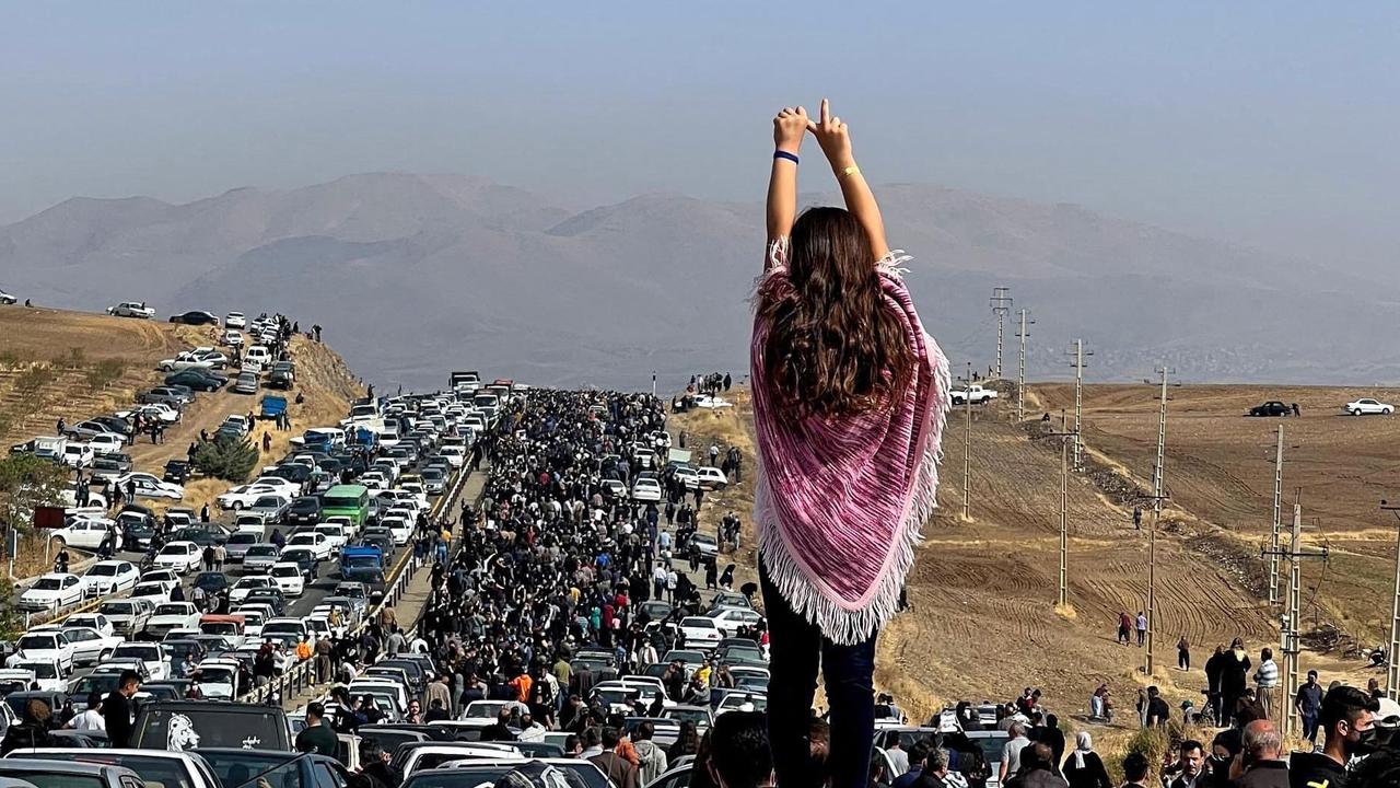 An unveiled woman standing on top of a vehicle as thousands make their way towards Aichi cemetery in Saqez, Mahsa Amini's home town in the western Iranian province of Kurdistan. Picture: UGC / AFP