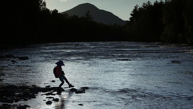 In this Tuesday, Aug. 8, 2017 photo, a youngster explores the Penobscot River's East Branch at the new Katahdin Woods and Waters National Monument near Patten, Maine. Interior Secretary Ryan Zinke wants to retain the newly created Katahdin Woods and Waters National Monument in northern Maine, but said he might recommend adjustments to the White House on Thursday, Aug. 24, 2017. (AP Photo/Robert F. Bukaty)