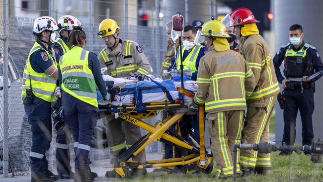 Paramedics stretcher a person from the scene of the crash. Picture: David Geraghty