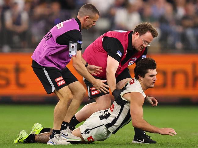 PERTH, AUSTRALIA - MAY 08: Lachie Schultz of the Magpies collapses in the hands of medical staff while walking from the field following a collision during the round nine AFL match between Fremantle Dockers and Collingwood Magpies at Optus Stadium, on May 08, 2025, in Perth, Australia. (Photo by Paul Kane/Getty Images)