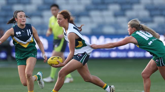 GEELONG, AUSTRALIA - AUGUST 31: Evie Cowcher of Team Morrison handballs whilst being tackled by Chloe Bown of Team Prespakis during the Marsh AFL National Futures Girls match between Team Morrison and Team Prespakis at GMHBA Stadium on August 31, 2024 in Geelong, Australia. (Photo by Daniel Pockett/AFL Photos/via Getty Images)