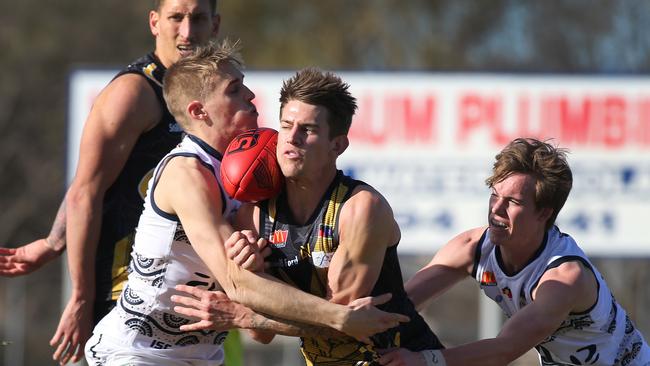 Glenelg's Elliott Chalmers is caught between South's Coby Helyar (L) and Cody Szust at Glenelg Oval. Picture: Dean Martin