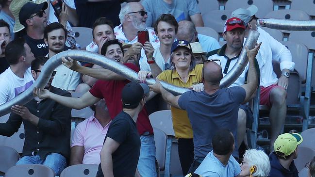 A security guard breaks up a Boxing Day beer snake. Picture: Michael Klein