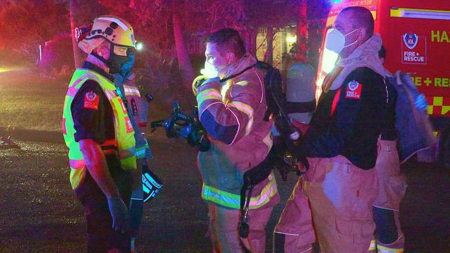 Firefighters put on breathing apparatus at the scene of a house fire at Eileen Drive, Corindi Beach, on January 18. Picture: Frank Redward.