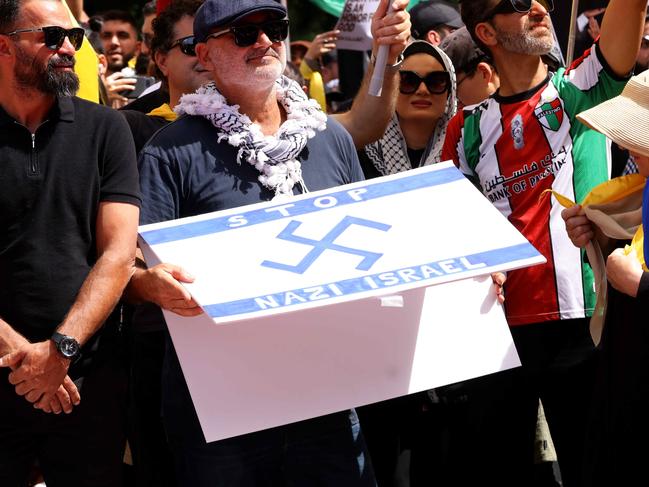 A protester holds a flag that has a Nazi-like symbol on it at the Sunday protest in Hyde Park. Picture: NewsWire / Damian Shaw