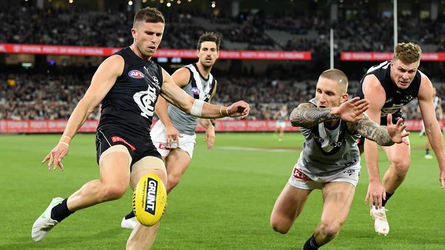 Hamish Hartlett of the Power smothers a kick by Marc Murphy of the Blues.