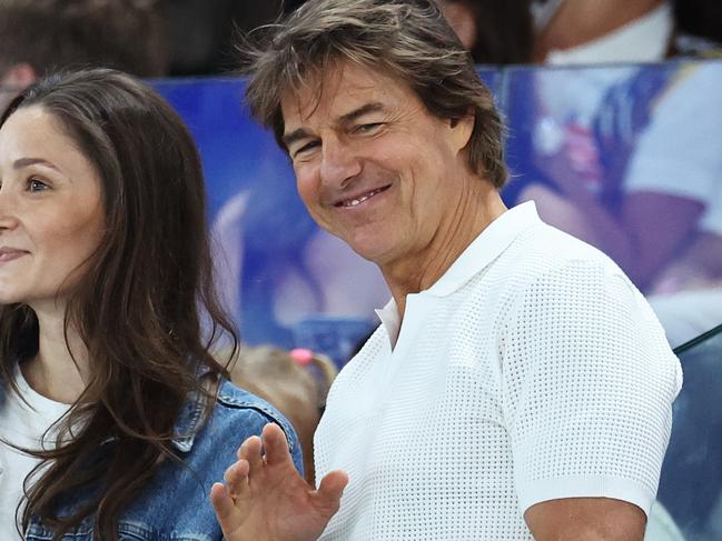 PARIS, FRANCE - JULY 28: Tom Cruise (R) waves during the Artistic Gymnastics Women's Qualification on day two of the Olympic Games Paris 2024 at Bercy Arena on July 28, 2024 in Paris, France. (Photo by Arturo Holmes/Getty Images)