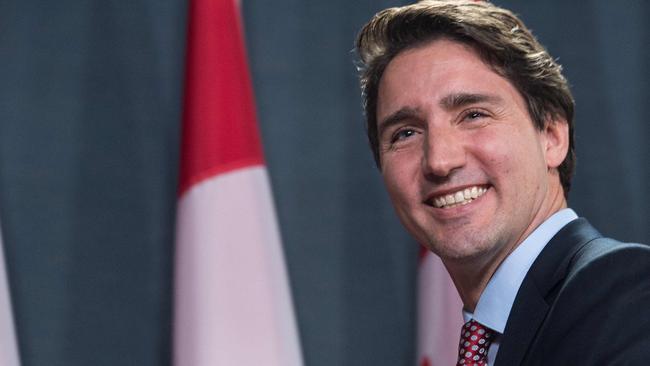 Canadian Liberal Party leader Justin Trudeau smiles at the end of a press conference in Ottawa on October 20, 2015 after winning the general elections. Liberal leader Justin Trudeau reached out to Canada's traditional allies after winning a landslide election mandate to change tack on global warming and return to the multilateralism sometimes shunned by his predecessor. AFP PHOTO/NICHOLAS KAMM