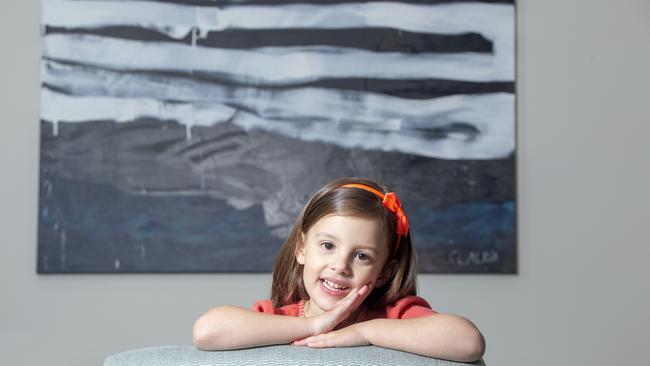 Claudia, 4, with one of her monochrome paintings. Picture: AAP/Renae Droop