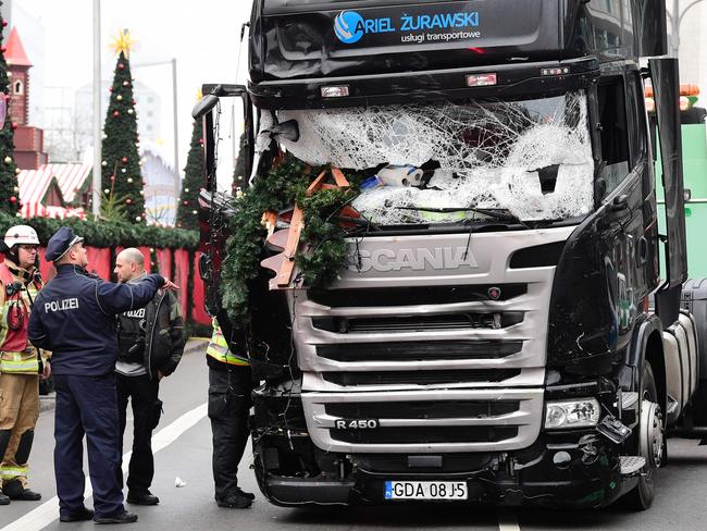 A policeman and firemen stand next to a truck at the scene where it crashed into a Christmas market in Berlin. Picture: AFP/Tobias Schwarz