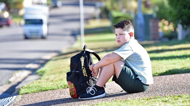 Kayden Beattie, 8, waiting to catch his bus to school on Dunning Avenue at Bateau Bay. Picture: Troy Snook