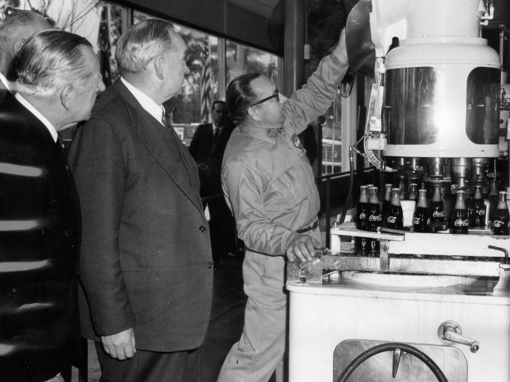 At the new bottling plant of Coca-Cola Bottlers, Thebarton, Sir Edward Hayward (Chairman of the Board of Directors of Coca-Cola) and SA Premier Sir Thomas Playford watch plant operator Mr V Bagusauskas. September 1, 1961. Picture: R Hewett