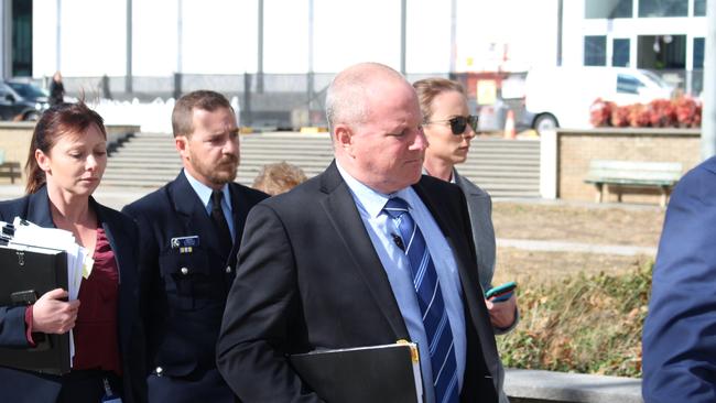 Acting Sergeant Nathan Macklin (in uniform) leaves court in August last year after giving evidence at the inquest into the death of Anthony Caristo.