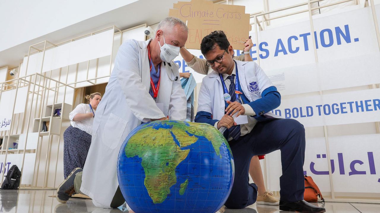 Environmental activists “perform CPR” on the earth at the COP28. Picture: Giuseppe Cacace / AFP