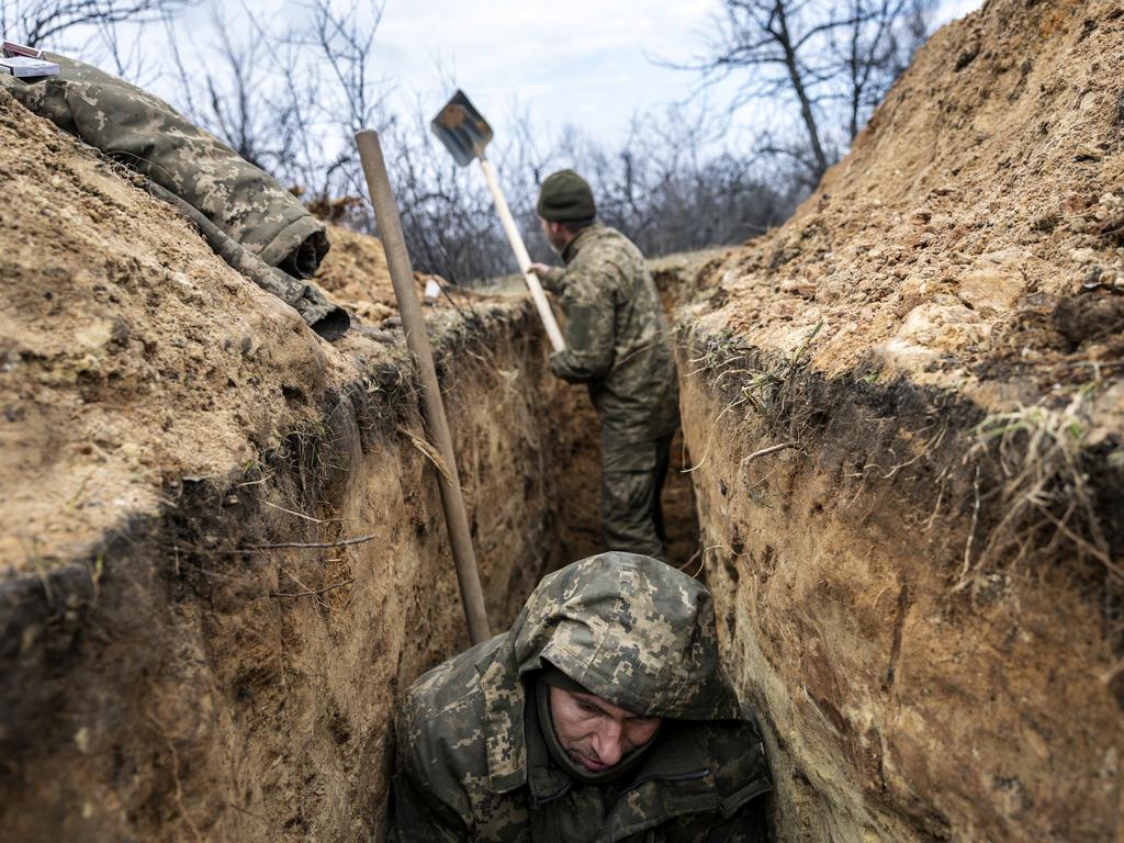 A Ukrainian infantryman takes cover in a partially dug trench along the frontline outside of Bakhmut, Ukraine. Picture: Getty Images