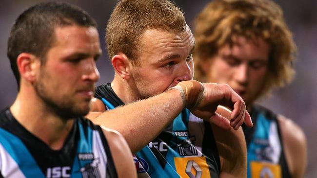 Port's Travis Boak, Andrew Moore and Aaron Young leave the ground after the demoralising loss to Fremantle.