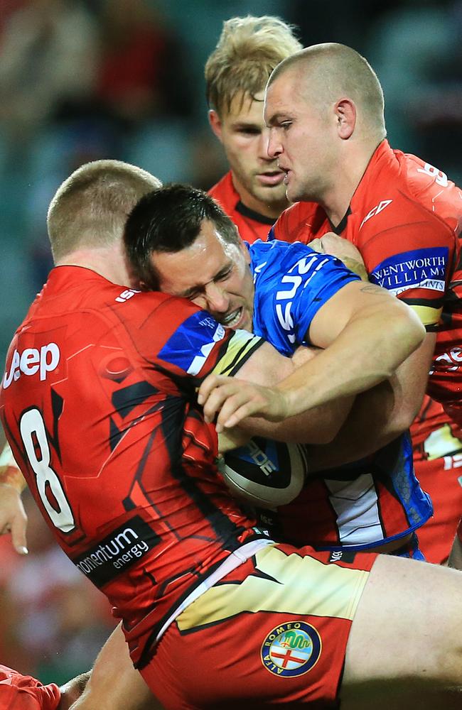 Mitchell Pearce is tackled by the Dragons defence.