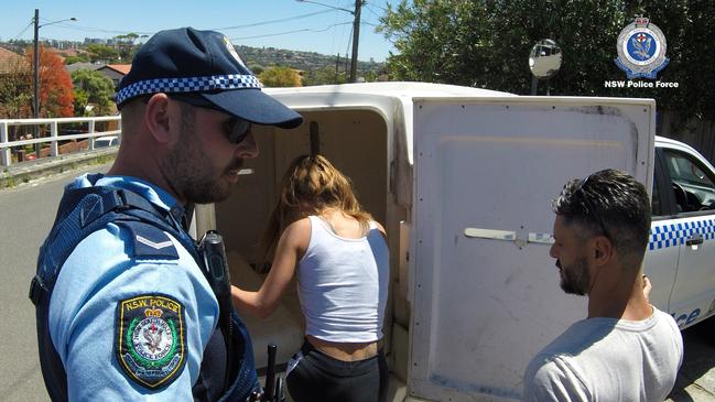 Danielle Hogan climbs into a police vehicle.