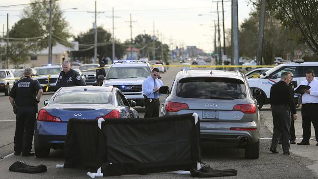 The body of former NFL player Joe McKnight lies between the shooter's vehicle at left and his Audi SUV at right as the Jefferson Parish Sheriff's Office investigates the scene.