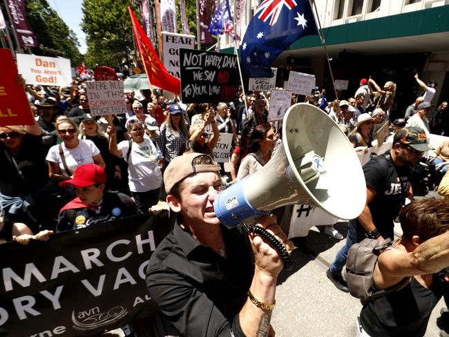 MELBOURNE, AUSTRALIA - NOVEMBER 27: A man protests with thousands of people down Bourke Street on November 27, 2021 in Melbourne, Australia. People gathered in Melbourne to protest against mandatory vaccination. (Photo by Darrian Traynor/Getty Images)