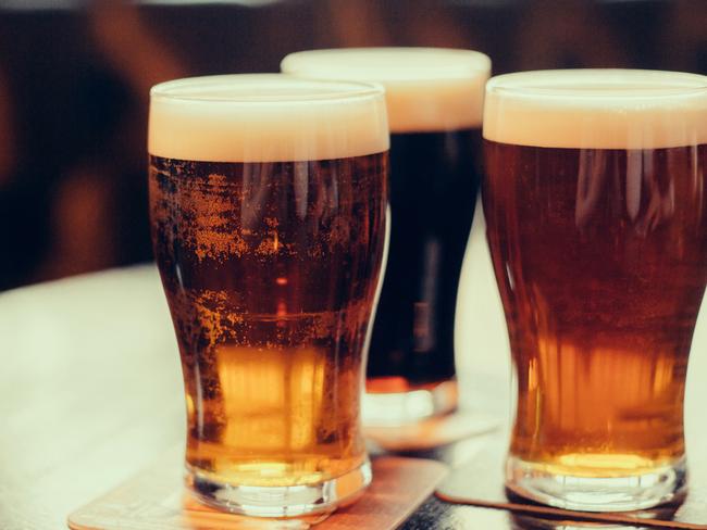 Glasses of light and dark beer on a pub background.