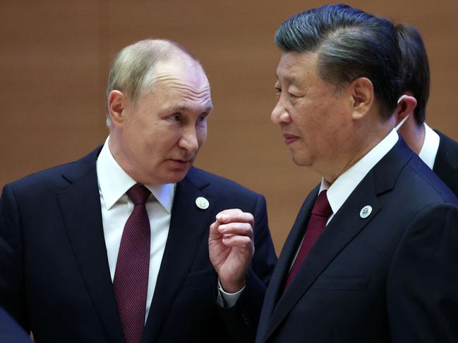 Russian President Vladimir Putin speaks to China's President Xi Jinping during the Shanghai Cooperation Organisation (SCO) leaders' summit in Samarkand on September 16, 2022. (Photo by Sergei BOBYLYOV / SPUTNIK / AFP)